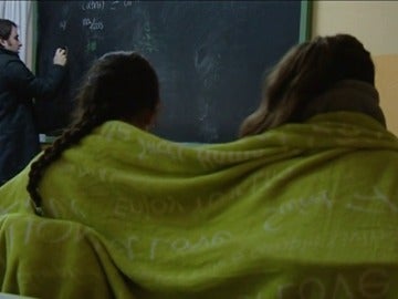 Imagen de dos alumnas dando clase abrigadas con una manta para soportar el frío Imagen de dos alumnas dando clase abrigadas con una manta para soportar el frío