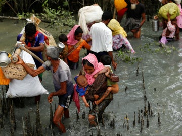 Refugiados rohingya caminan a través del agua después de cruzar la frontera en barco a través del río Naf en Teknaf, Bangladesh Refugiados rohingya caminan a través del agua después de cruzar la frontera en barco a través del río Naf en Teknaf, Bangladesh