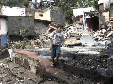Un niño carga una silla en medio de los escombros en el cantón de Escazú