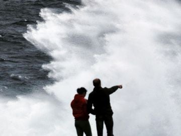 Un grupo de turistas obvervan las olas esta tarde en Muxía, A Coruña