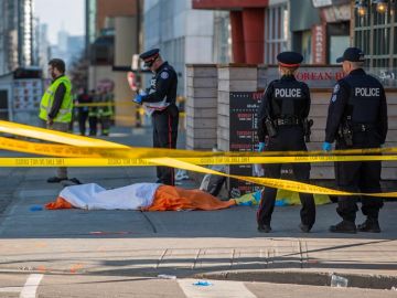 Oficiales de la policía de Toronto vigilan frente al cuerpo de una de las víctimas Oficiales de la policía de Toronto vigilan frente al cuerpo de una de las víctimas