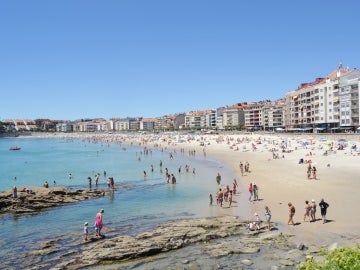 Con el día soleado la gente disfrutaba de la playa Con el día soleado la gente disfrutaba de la playa