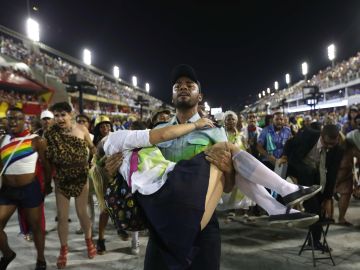 Representación de la violencia en Rio de Janeiro con un policía cargando una estudiante tiroteada Representación de la violencia en Rio de Janeiro con un policía cargando una estudiante tiroteada