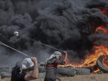 Dos palestinos lanzan piedras en una protesta en Gaza Dos palestinos lanzan piedras en una protesta en Gaza