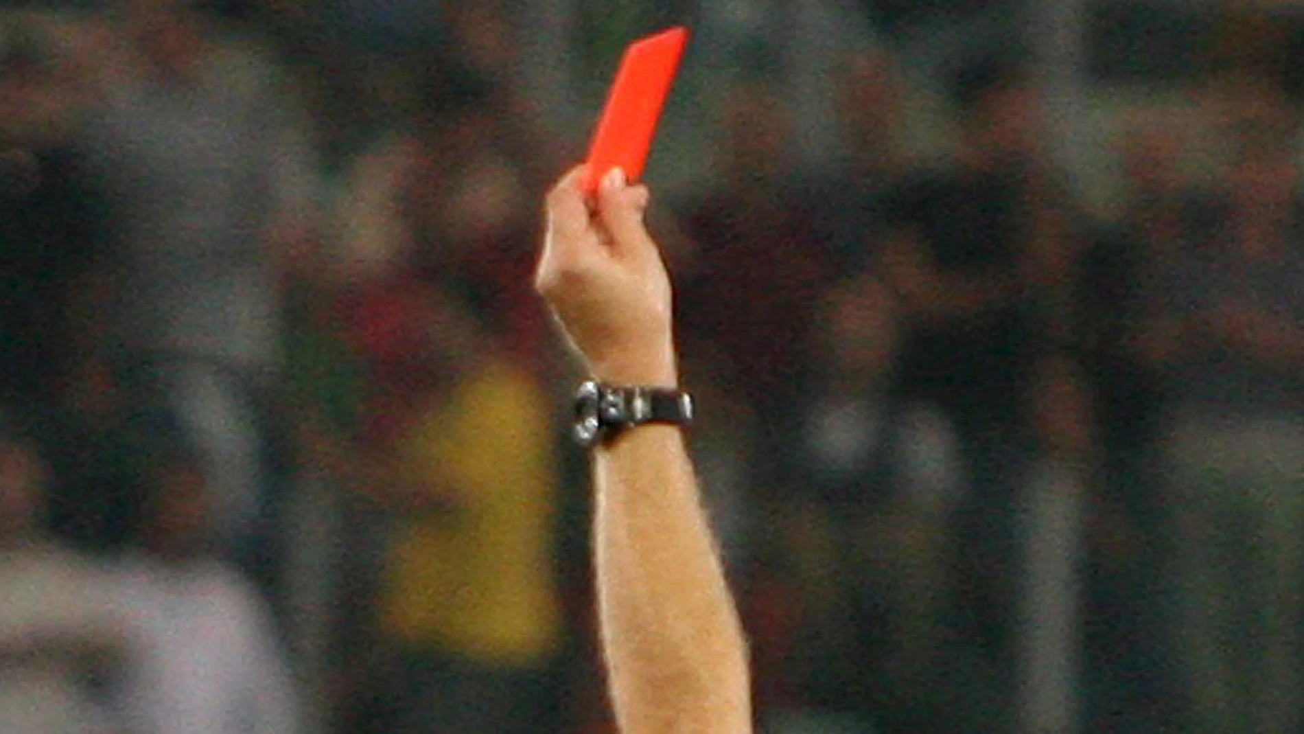 Un árbitro muestra la tarjeta roja
