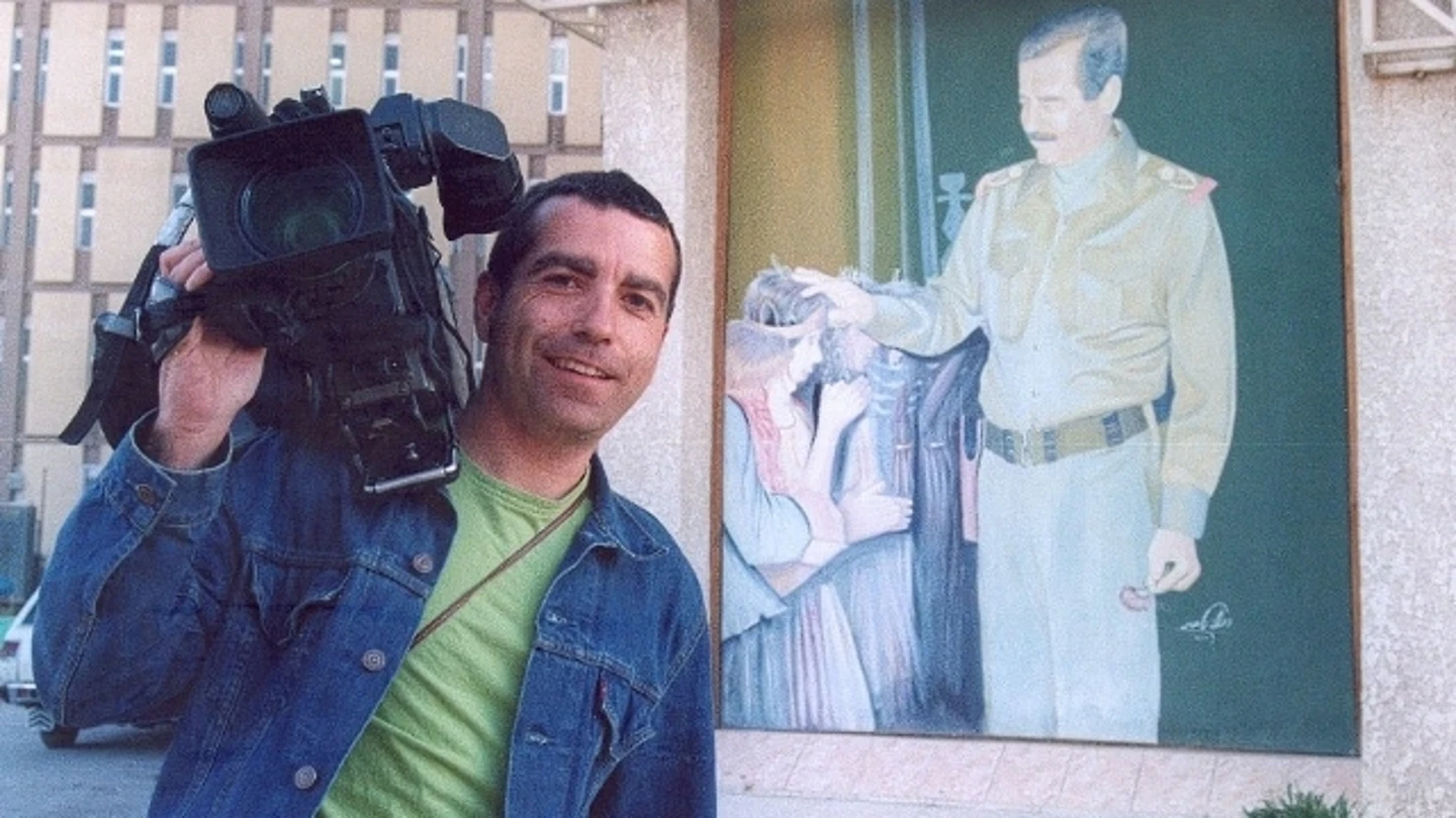 José Couso junto a un cartel de Saddam José Couso junto a un cartel de Saddam