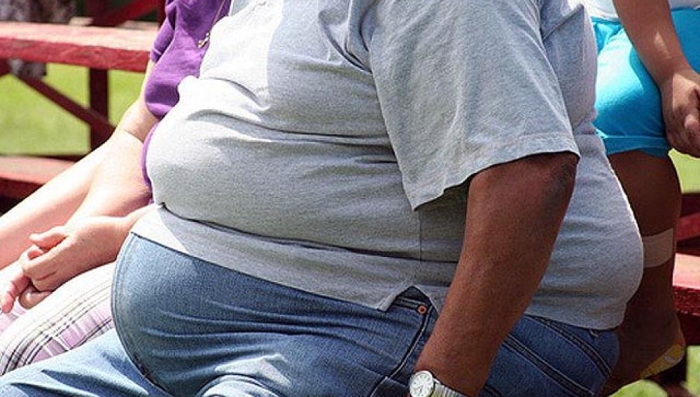 Un hombre obeso sentado en un banco