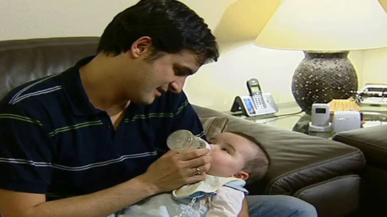 Un padre da el biberón a su bebé Un padre da el biberón a su bebé