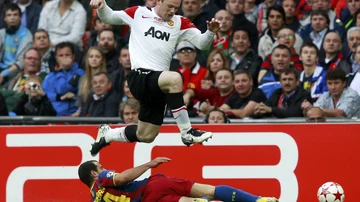 Rooney salta para evitar una entrada de Mascherano