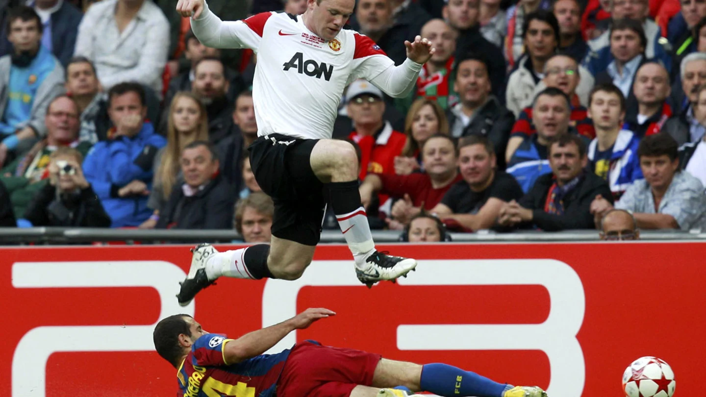 Rooney salta para evitar una entrada de Mascherano Rooney salta para evitar una entrada de Mascherano