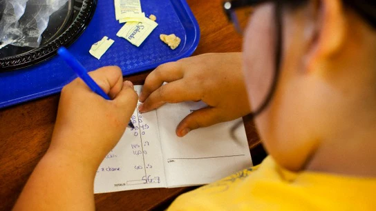 Niña haciendo los deberes después de comer Niña haciendo los deberes después de comer