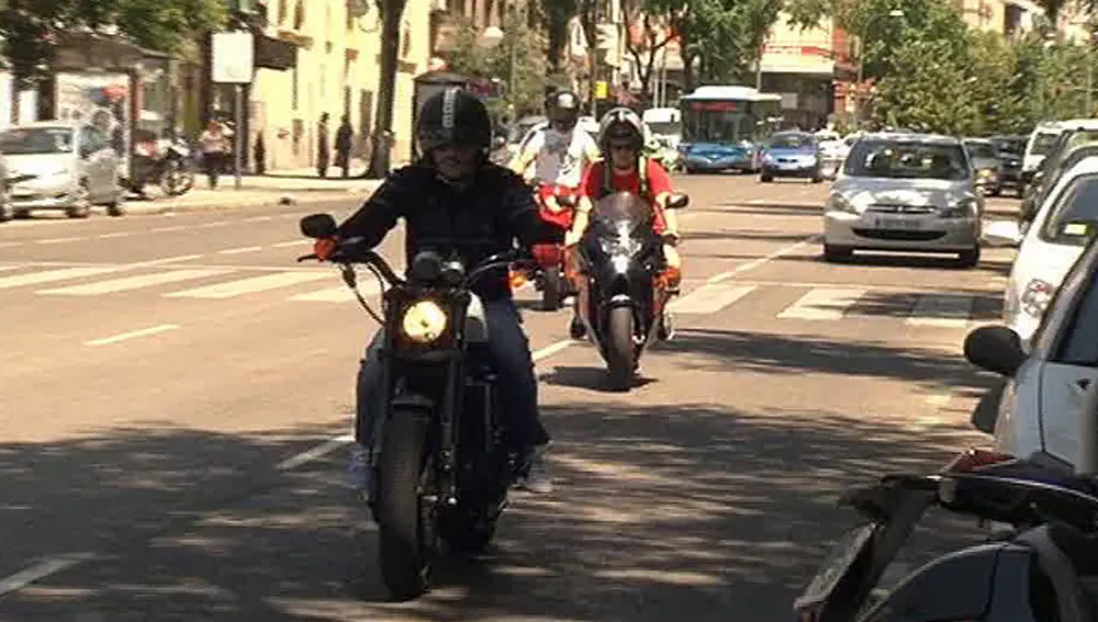Dos motoristas por las calles de Madrid