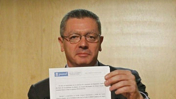 Alberto Ruiz-Gallardón, muestra el documento que trasladará al pleno municipal para su aprobación