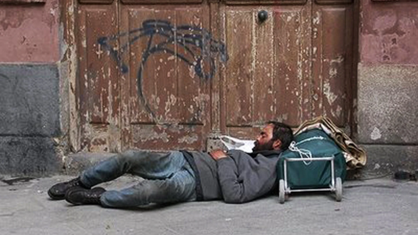 Imagen de archivo de una persona indigente que duerme en la calle. Imagen de archivo de una persona indigente que duerme en la calle.