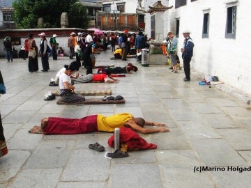 Budistas tibetanos postrados ante el templo de Jokhang, en Lhasa. Foto: Marino Holgado