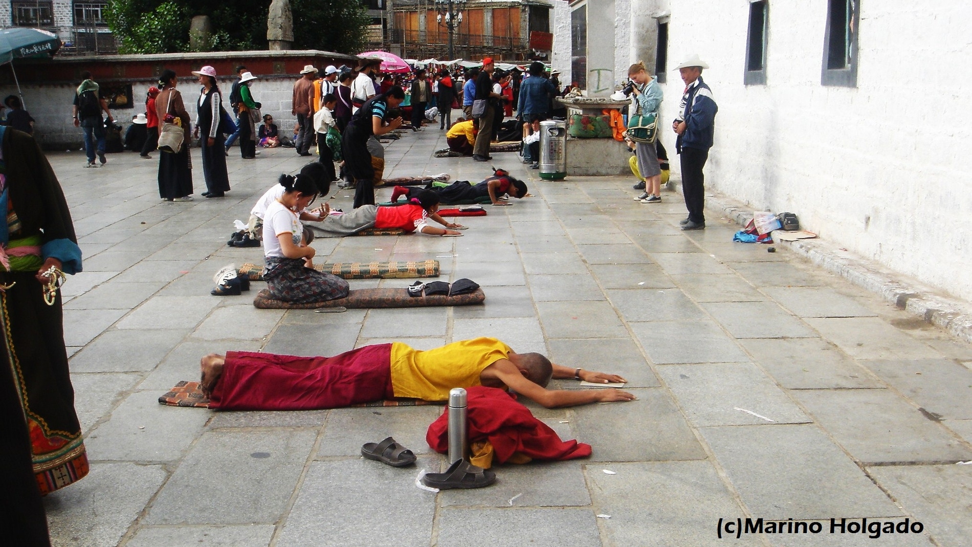 Budistas tibetanos postrados ante el templo de Jokhang, en Lhasa. Foto: Marino Holgado