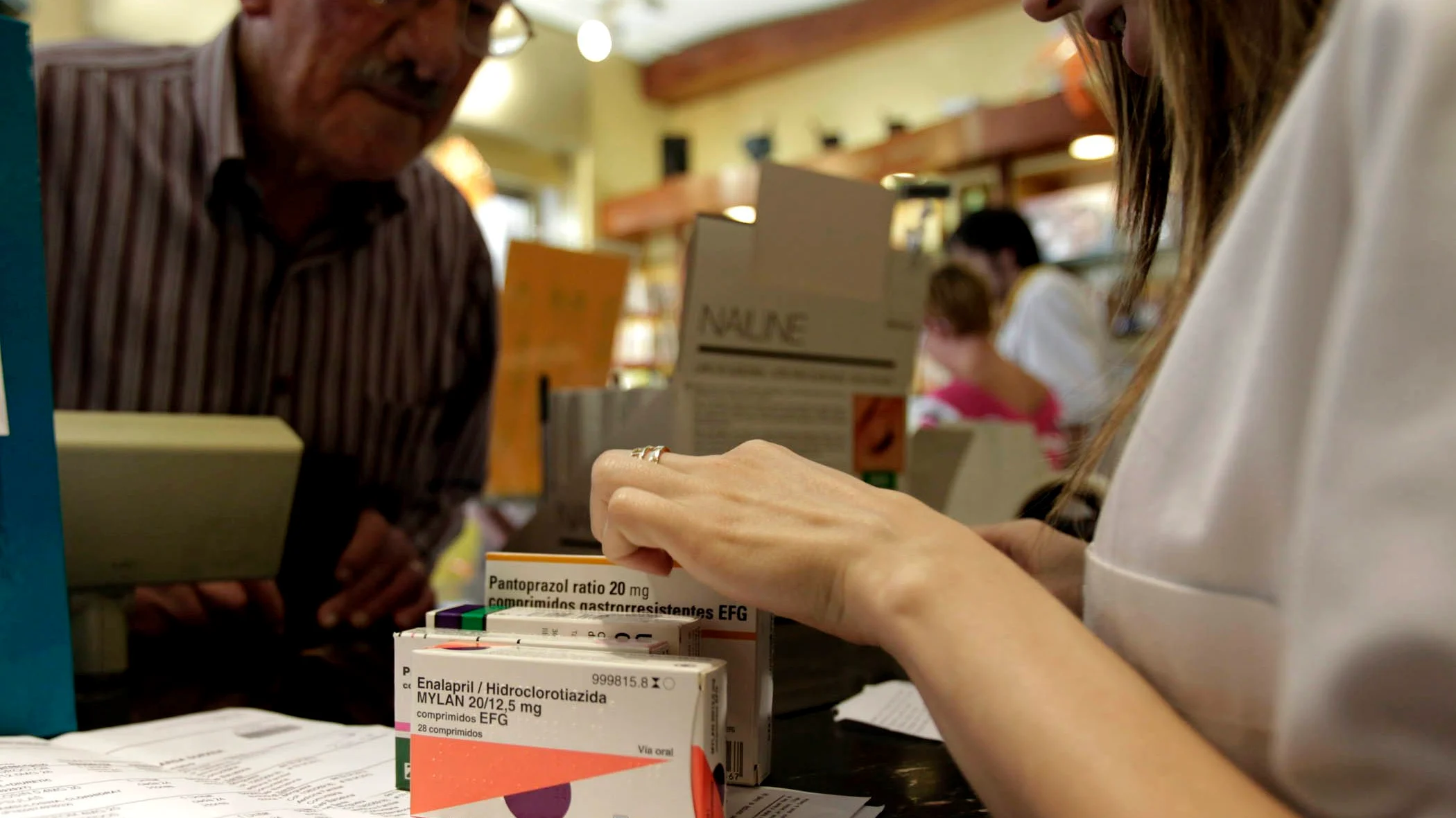 Un hombre comprando medicamentos en la farmacia