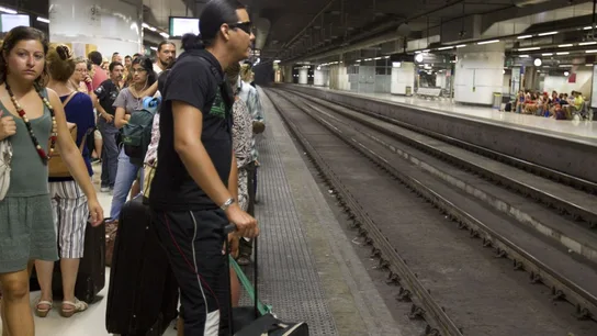 Los viajeros esperan la llegada de un tren Los viajeros esperan la llegada de un tren