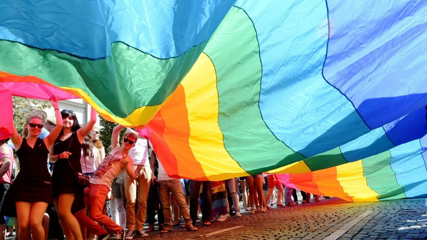 Una bandera arco iris durante un desfile del orgullo Una bandera arco iris durante un desfile del orgullo