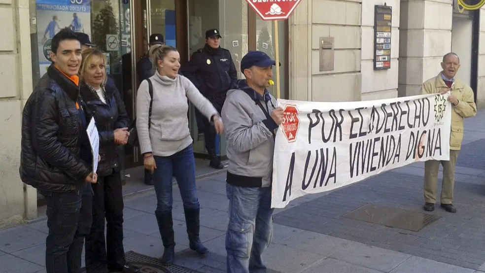 Miembros de una familia protestan frente a un banco