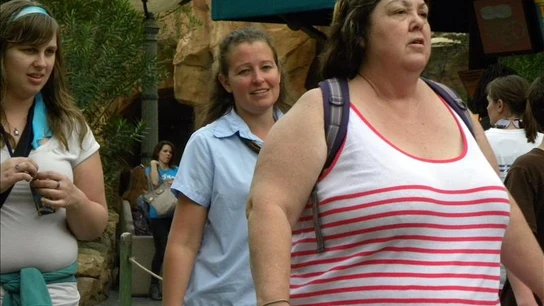 Una mujer obesa camina por la calle. Una mujer obesa camina por la calle.