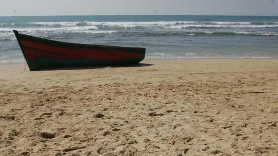 Imagen de una patera sobre una playa Imagen de una patera sobre una playa