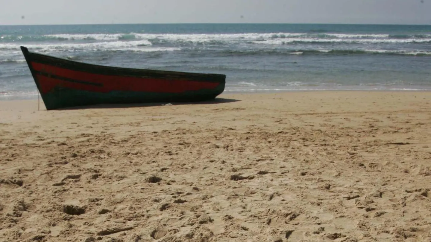 Imagen de una patera sobre una playa Imagen de una patera sobre una playa