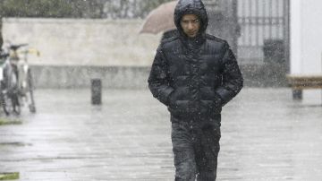 Un hombre camina por una calle de Vitoria mientras nieva