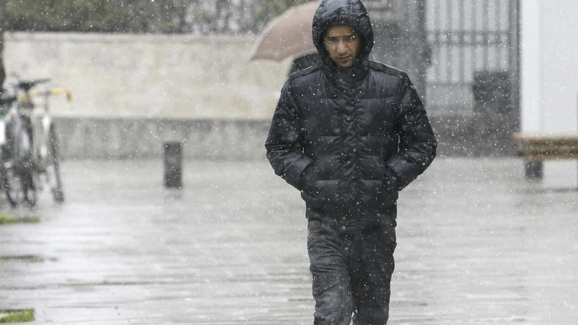 Un hombre camina por una calle de Vitoria mientras nieva