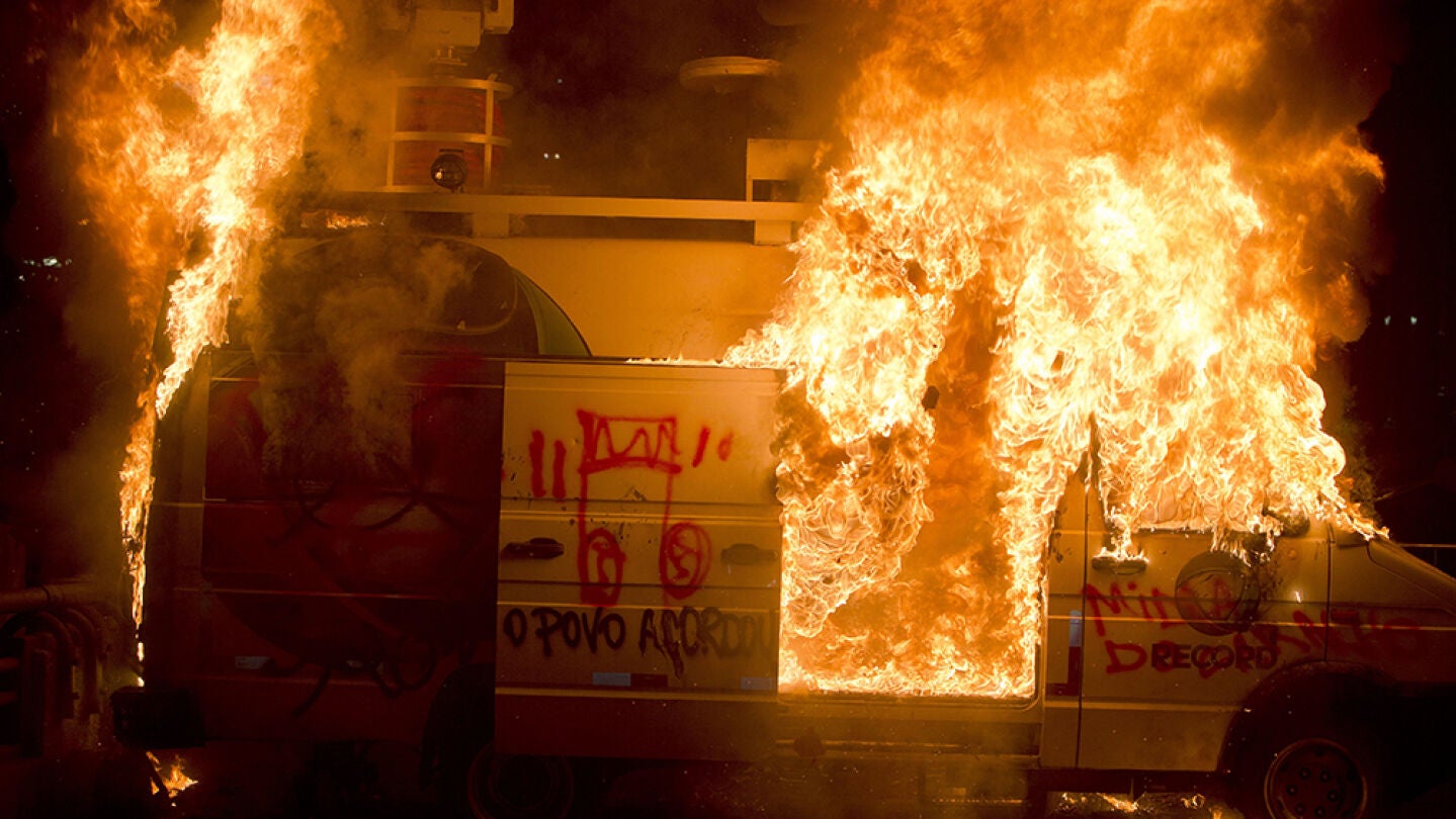 El veh&iacute;culo de la cadena de televisi&oacute;n TV Record arde durante una protesta 