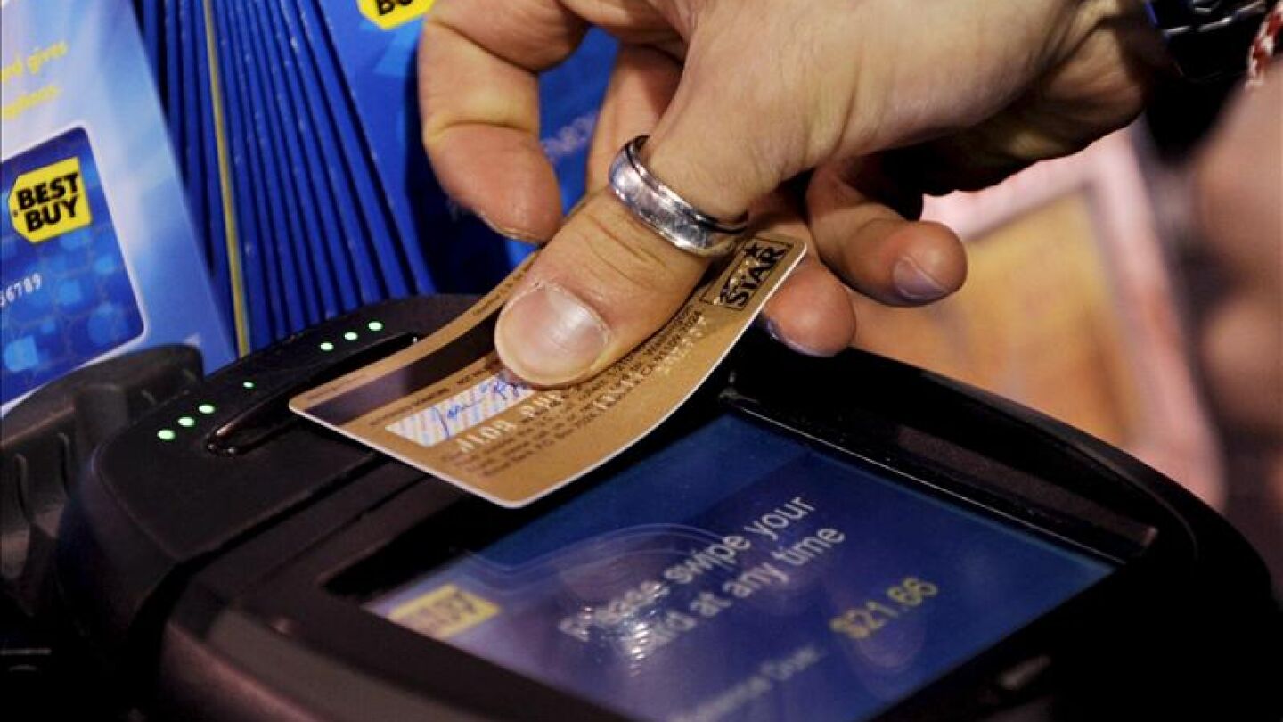Una persona usa su tarjeta de cr&eacute;dito para una de sus compras.