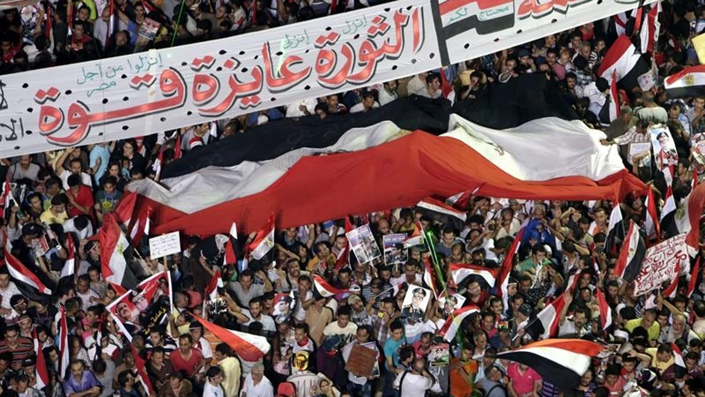 Varias personas ondean una bandera egipcia, a favor de las fuerzas armadas en la plaza Tahrir Varias personas ondean una bandera egipcia, a favor de las fuerzas armadas en la plaza Tahrir