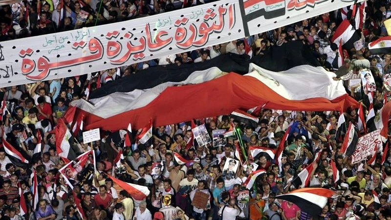Varias personas ondean una bandera egipcia, a favor de las fuerzas armadas en la plaza Tahrir Varias personas ondean una bandera egipcia, a favor de las fuerzas armadas en la plaza Tahrir