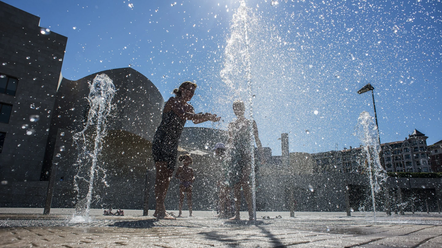 Dos mujeres se refrescan en una fuente. Dos mujeres se refrescan en una fuente.