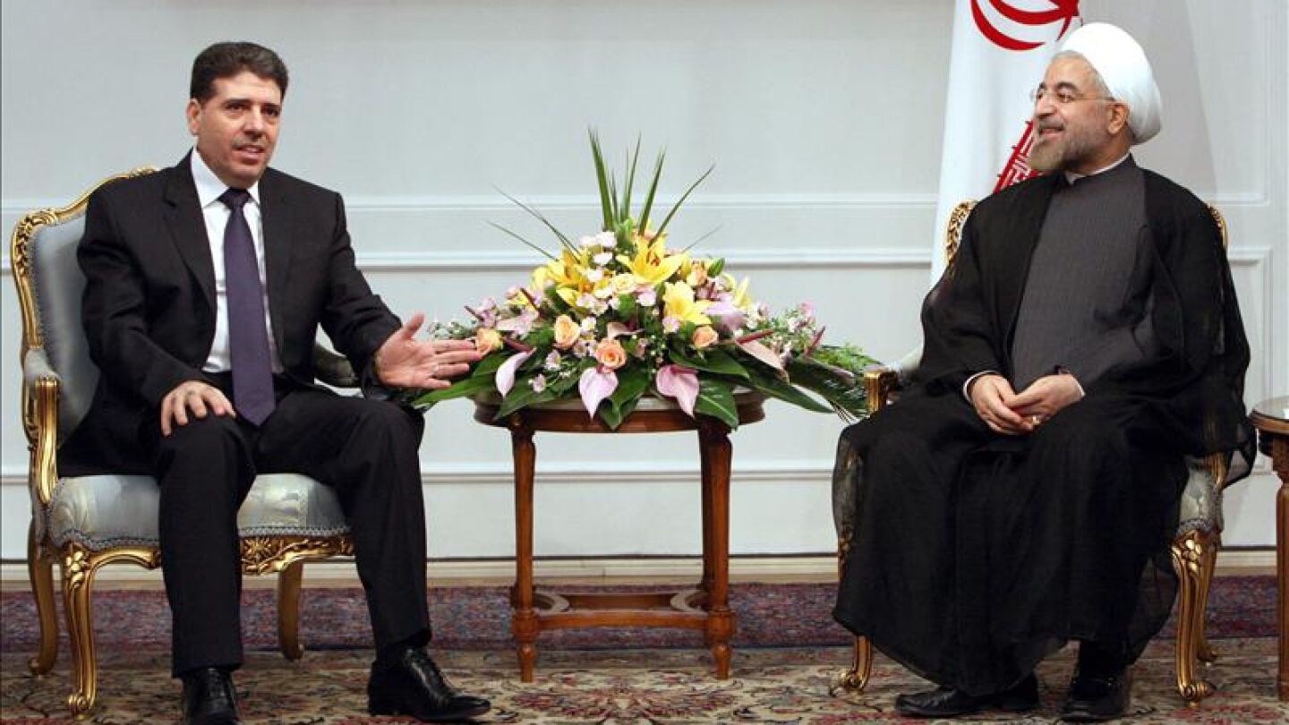 El primer ministro sirio, Wael Nader Al-Halqi, habla con el presidente iran&iacute;, Hassan Rohan&iacute;,