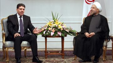 El primer ministro sirio, Wael Nader Al-Halqi, habla con el presidente iraní, Hassan Rohaní,