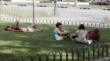 Parque de Madrid con gente sobre la hierba