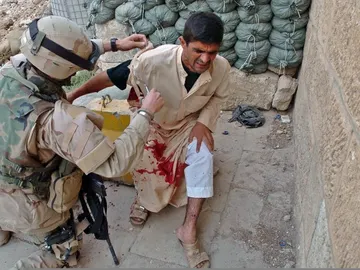 Un soldado atiende a un herido civil tras un ataque suicida que mató a 33 en Tall Afar (2005). Un soldado atiende a un herido civil tras un ataque suicida que mató a 33 en Tall Afar (2005).