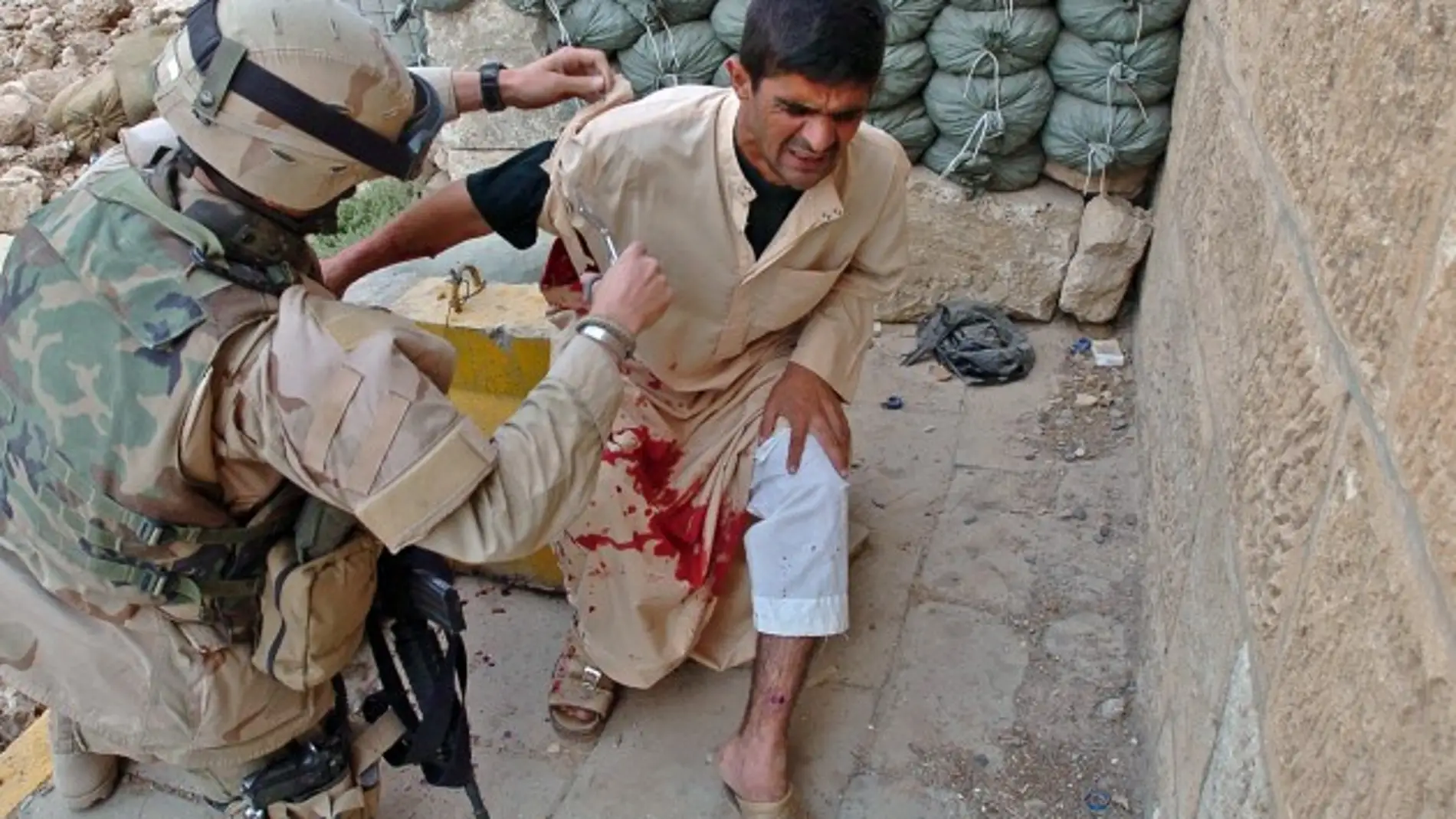 Un soldado atiende a un herido civil tras un ataque suicida que mató a 33 en Tall Afar (2005).