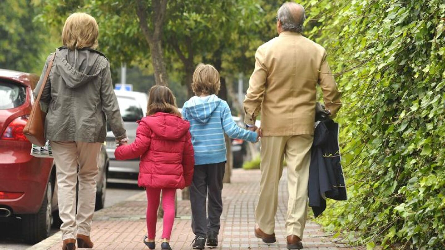 Unos abuelos acompa&ntilde;an a sus niestos al colegio.