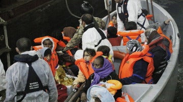 Una barca de salvamento llega al buque anfibio 'San Marco Mare Nostrum' con inmigrantes rescatados.