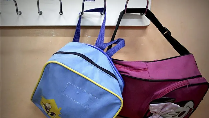Dos mochilas escolares en un aul Dos mochilas escolares en un aul