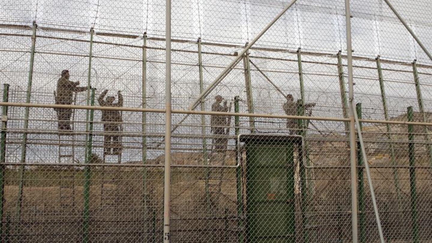 Varios operarios colocan a lo largo del per&iacute;metro fronterizo de Melilla