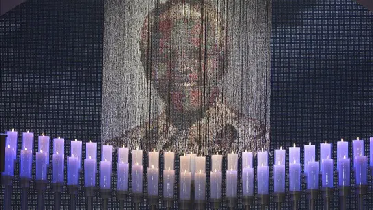 Velas encendidas bajo un retrato de Neslon Mandela Velas encendidas bajo un retrato de Neslon Mandela