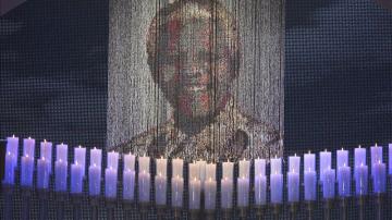 Velas encendidas bajo un retrato de Neslon Mandela 
