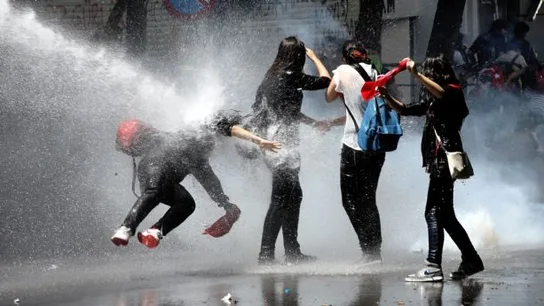 Unos manifestantes son alcanzados por un cañón de agua de la policía antidisturbios Unos manifestantes son alcanzados por un cañón de agua de la policía antidisturbios