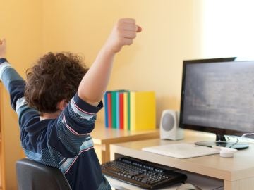 Un niño pequeño frente a su ordenador Un niño pequeño frente a su ordenador