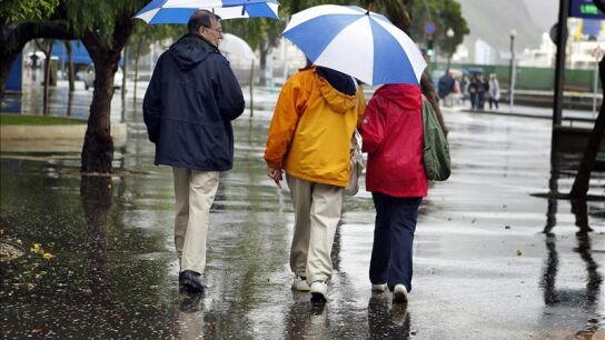 Varios turista se protegen de la lluvia