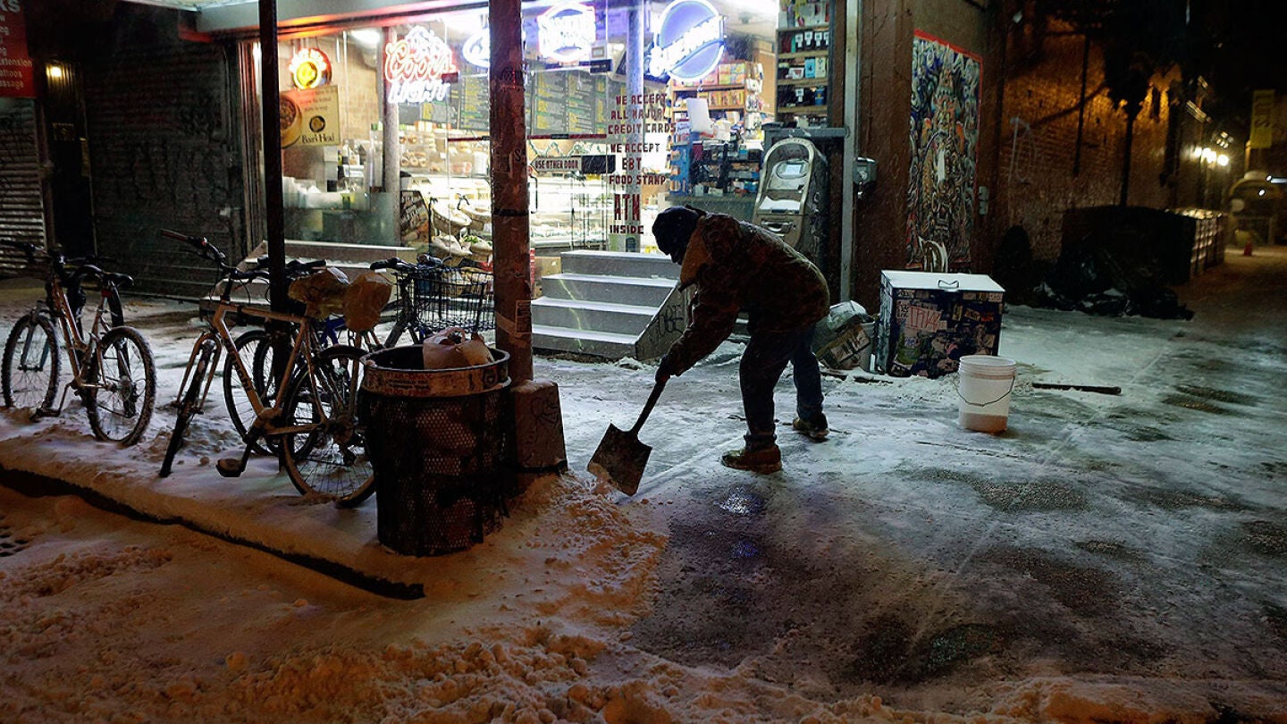 Un hombre retira nieve de la calle en Nueva York