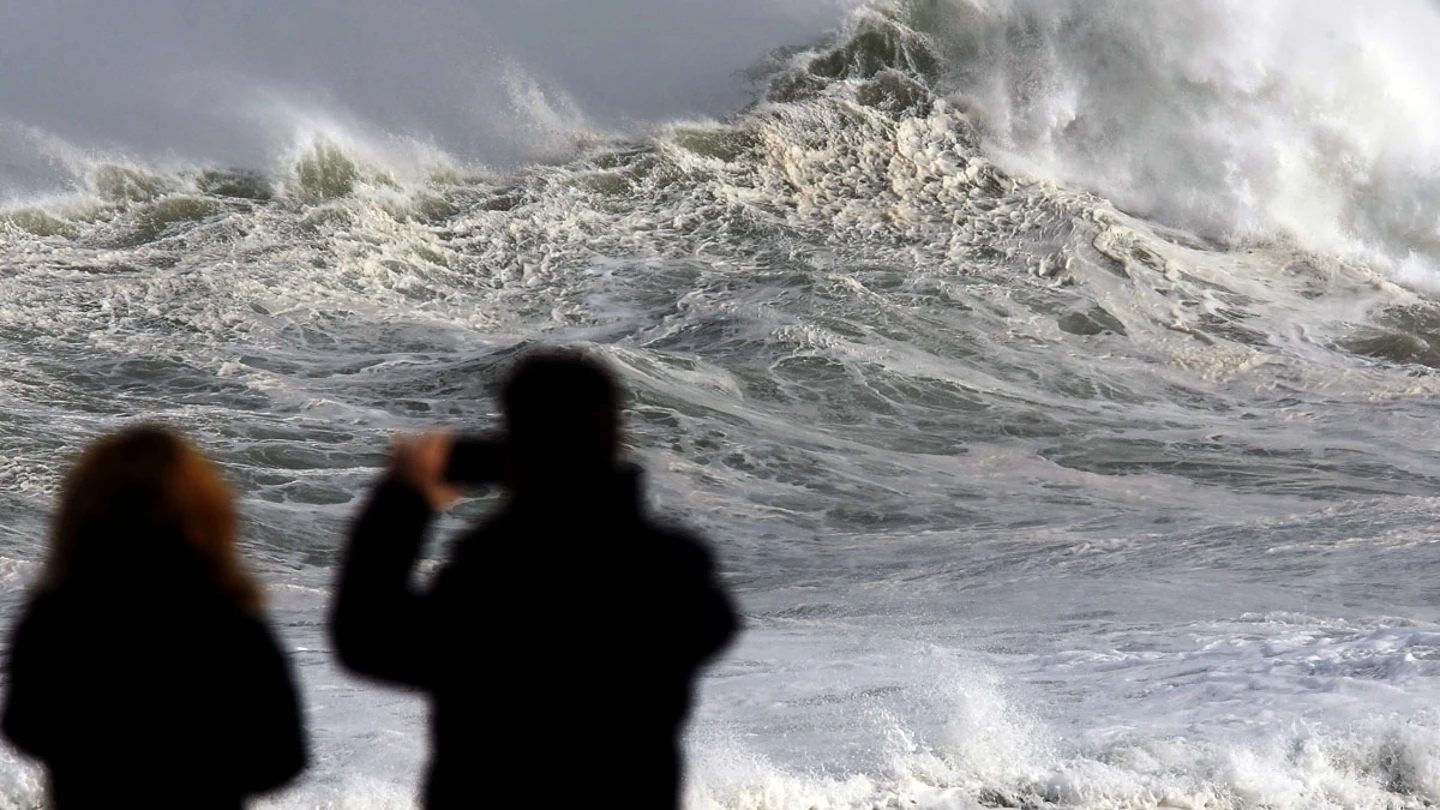Dos personas fotografían el fuerte oleaje Dos personas fotografían el fuerte oleaje